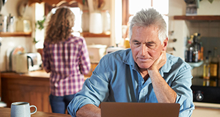 Mature man using a laptop at home